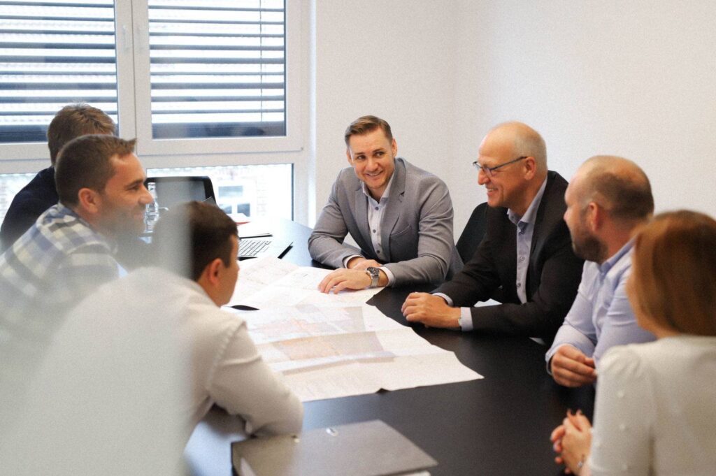 Teambild aller Mitarbeiter an einen Konferenztisch